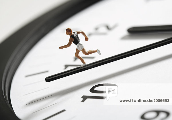 Symbol für Die Zeit rennt  Läuferfigur auf Uhrzeiger