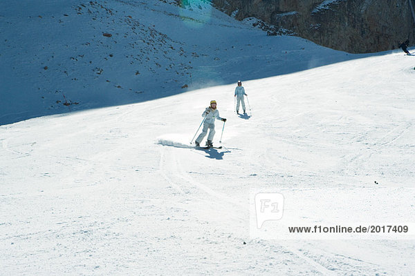 Junge Skifahrer auf der Piste  volle Länge  in der Ferne
