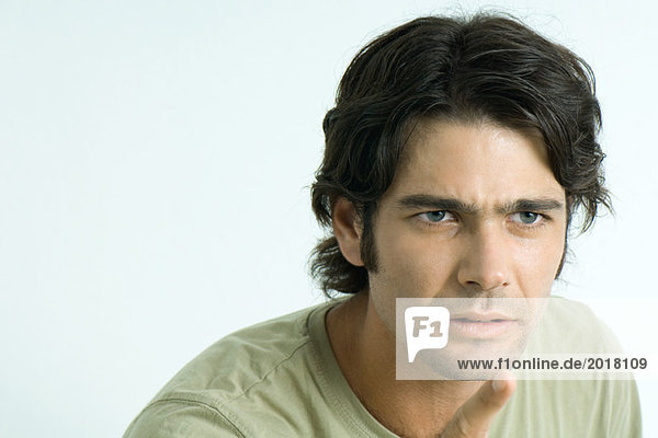 Man looking angry  pointing out of frame  portrait