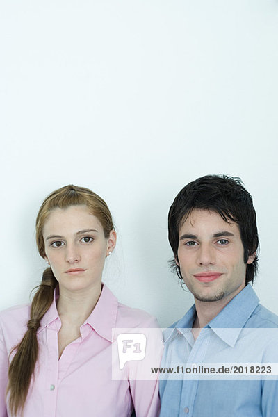 Young couple looking at camera  head and shoulders  portrait