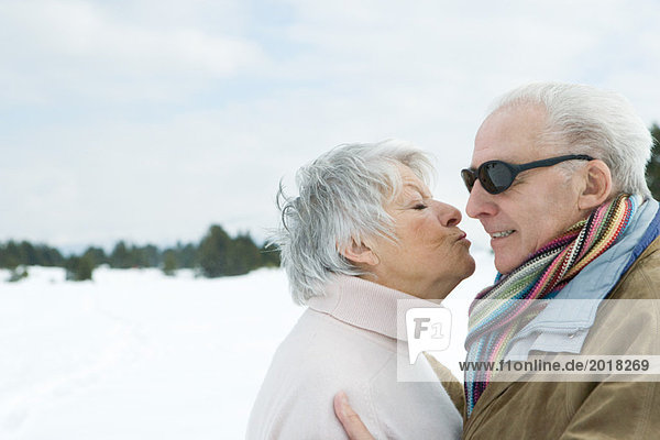 Seniorenpaar stehend von Angesicht zu Angesicht  Küssen  Seitenansicht
