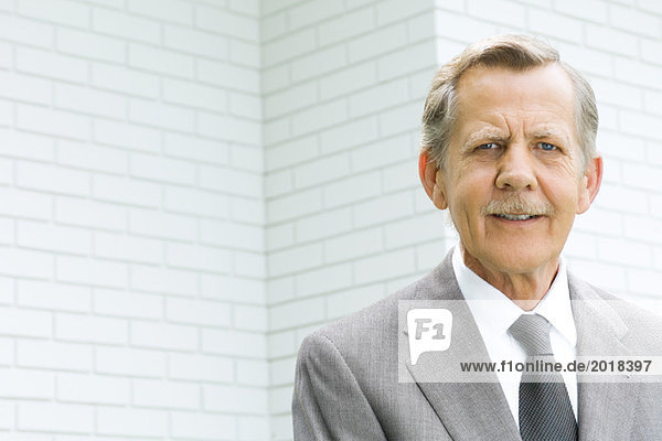 Senior Geschäftsmann lächelt vor der Kamera  Porträt