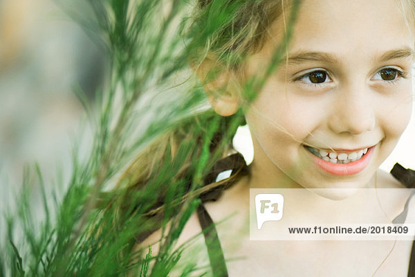 Mädchen neben hohem Gras  lächelnd  wegschauend  Portrait