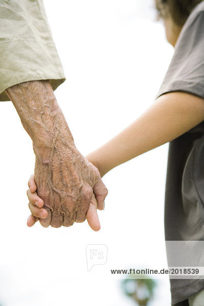 Seniorin und Junge halten Händchen  Ausschnitt  Nahaufnahme