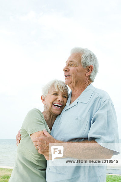 Seniorenpaar umarmend und lachend  Taille oben