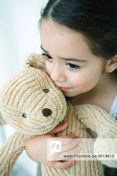 Kleines Mädchen hält Teddybär  schaut weg  Portrait