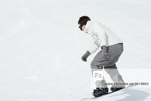 Young man snowboarding  full length