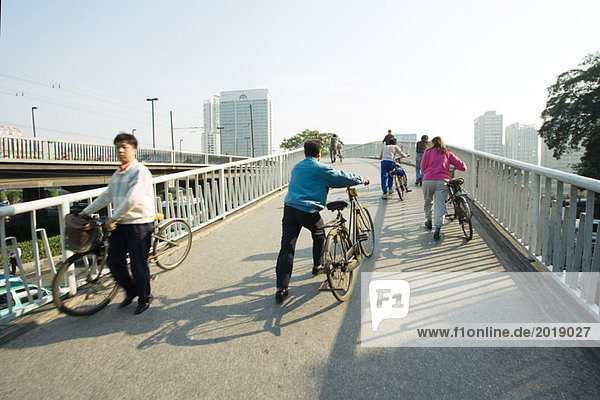 China  Provinz Guangdong  Guangzhou  Radfahrer überqueren Brücke