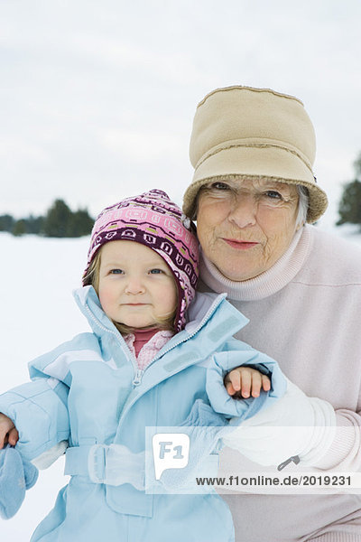 Grandmother and granddaughter smiling  dressed in winter clothing  portrait