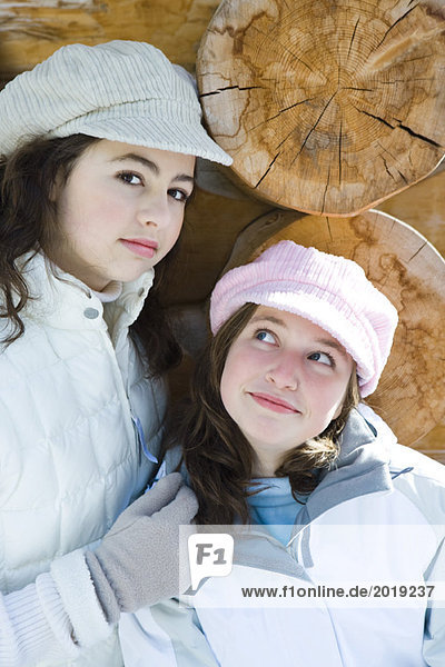 Zwei junge Freunde lächeln  tragen Mützen. Einer schaut in die Kamera  Portrait