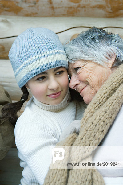 Grandmother and granddaughter  smiling  cheek to cheek  portrait