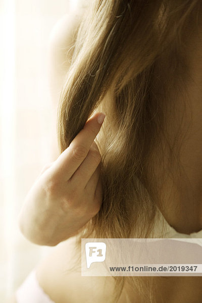 Junge Frau mit BH  laufende Finger durch langes Haar  abgeschnitten
