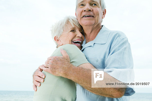 Seniorenpaar umarmend  Frau lachend  tiefer Blickwinkel