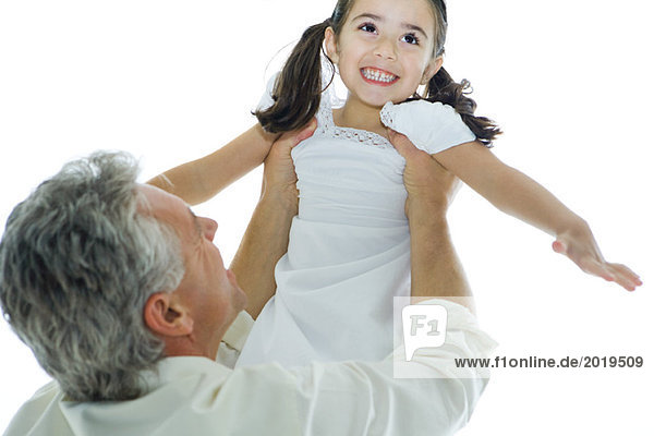 Mature man lifting up little girl into the air