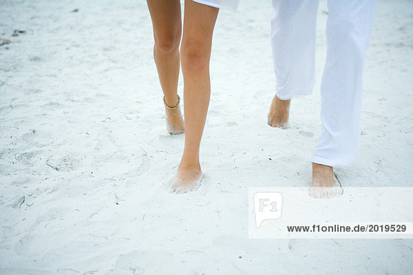 Paar auf Sand gehen  Blick auf die Beine abgeschnitten