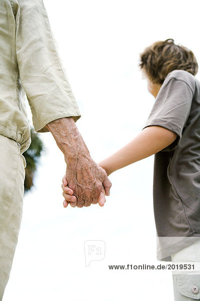 Seniorin und Enkelin beim Händchenhalten  abgeschnitten  Blickwinkel niedrig