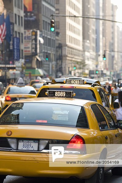 Taxis  die eine Straße in Manhattan hinunterfahren.