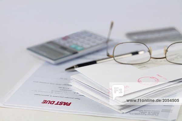 Kuvertstapel mit Stift  Taschenrechner  Brille und Kreditkarte