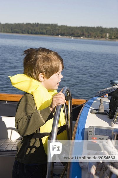 A boy steering a boat