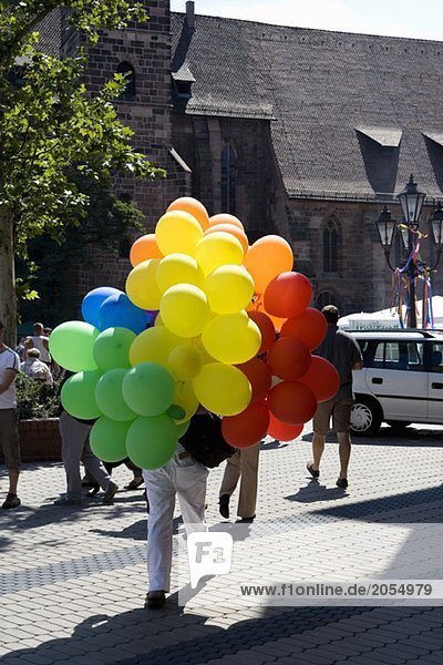 A person carrying a bunch of balloons