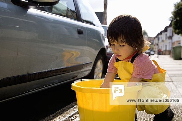 A young boy washing a car