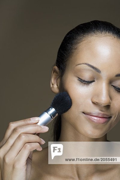 A woman applying face powder