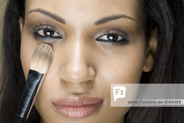 A woman applying eye shadow