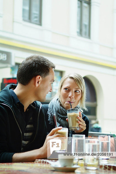 Mädchen und Kerl sitzen in einem Café.