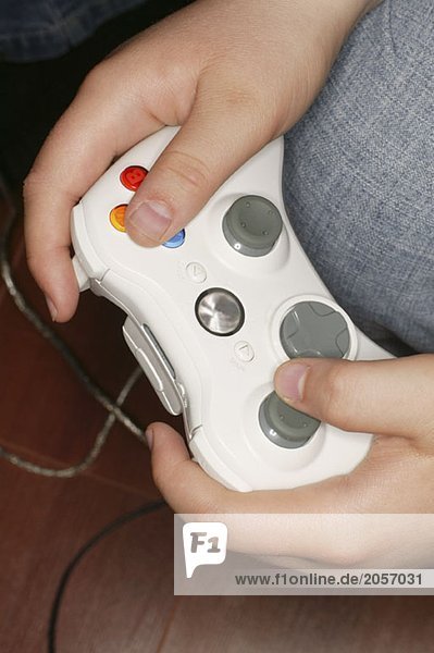 Ein Junge hält eine weiße Videospielsteuerung in den Händen