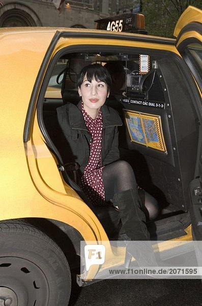 Junge Frau steigt aus einem Taxi  New York City