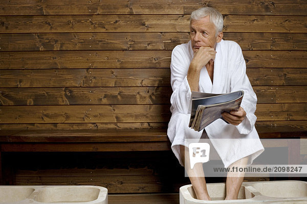 Germany  senior man having foot bath in health spa