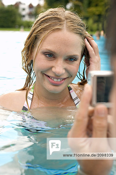 Deutschland  junger Mann fotografiert Frau im Pool