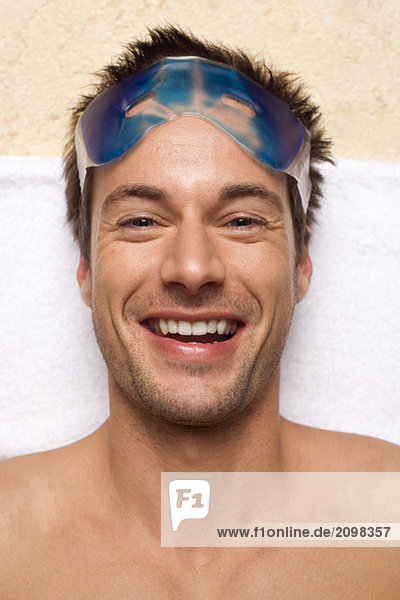 Germany  Man relaxing  wearing gel eye mask  close-up  portrait
