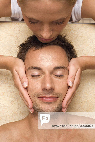 Germany  man receiving facial massage  close-up