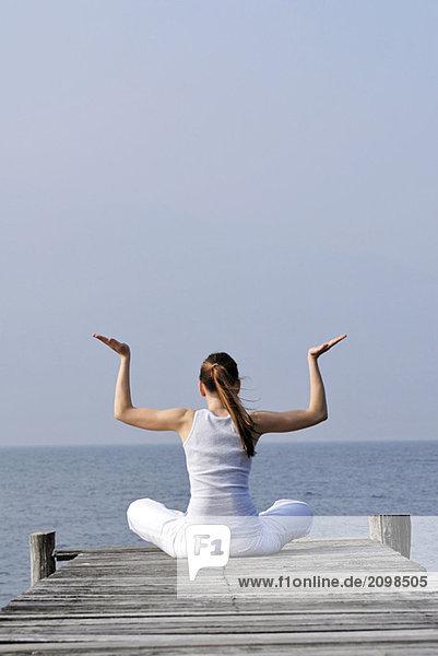 Italien  Gardasee  Frau (20-25) beim Yoga am Steg