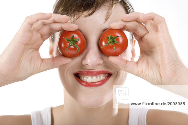 Frau  Augen mit Tomaten bedeckt  Nahaufnahme