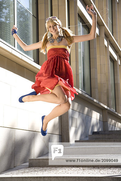 Woman jumping of joy  wearing red dress