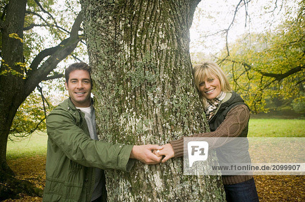 Germany  Baden-Württemberg  Swabian mountains  Couple smiling and hugging tree  portrait