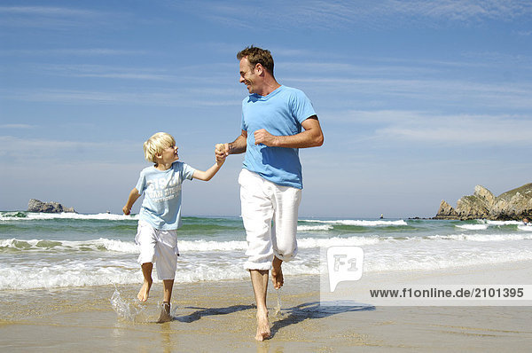Mann mit seinem Sohn am Strand
