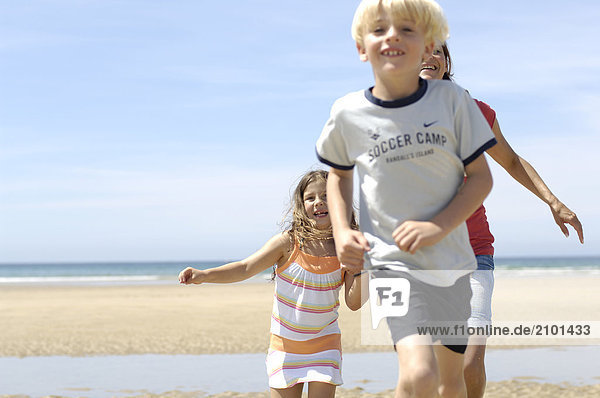 Woman running with her two children on beach