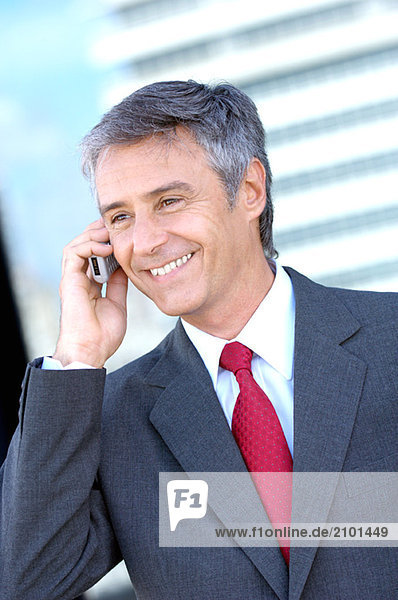 Businessman using mobile phone  smiling