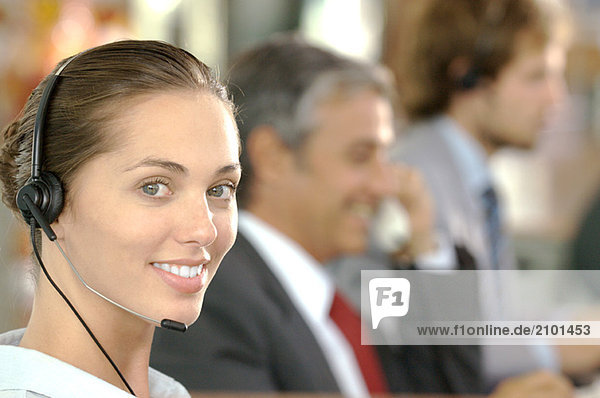 Businesswoman wearing headset  smiling  side view