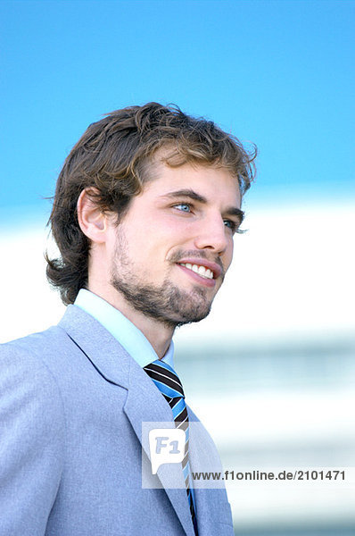 Young businessman smiling  side view