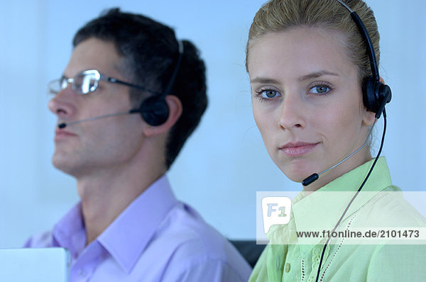 Junger Geschäftsmann und Geschäftsfrau mit Headset