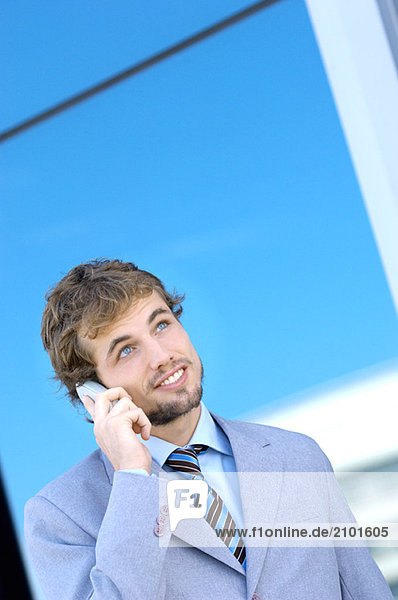 Young businessman using mobile phone  smiling