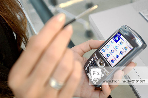 Woman holding mobile phone and stylus  close-up