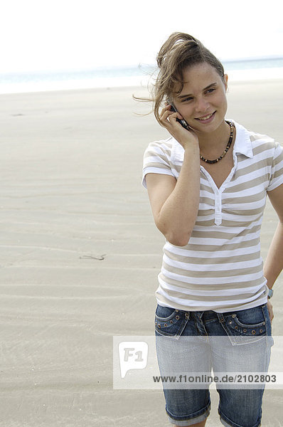 Nahaufnahme Teenagerin reden auf Handy am Strand