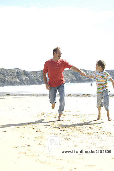 Man and his son running on beach
