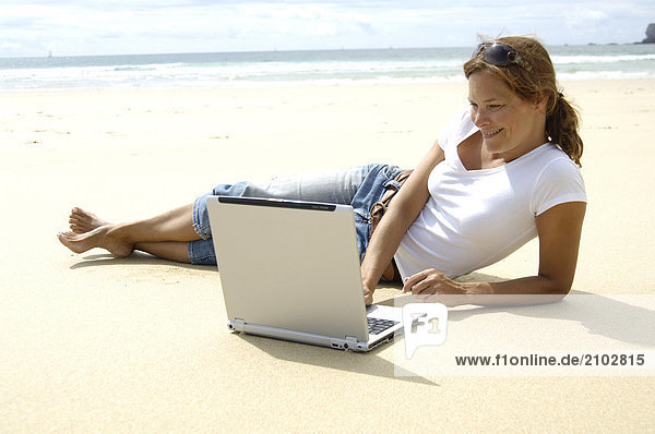 Nahaufnahme Frau mit Laptop am Strand