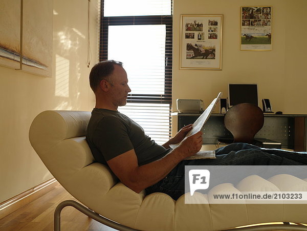 Profil Profile Mann Entspannung Stuhl Seitenansicht Zeitung vorlesen